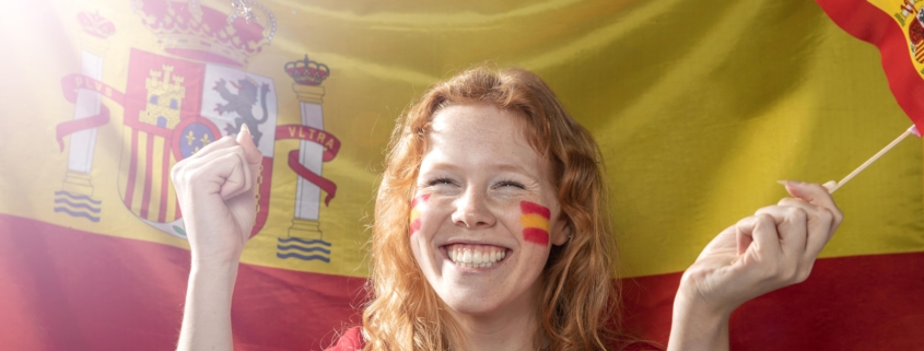 mujer sonriente sosteniendo la bandera espanola