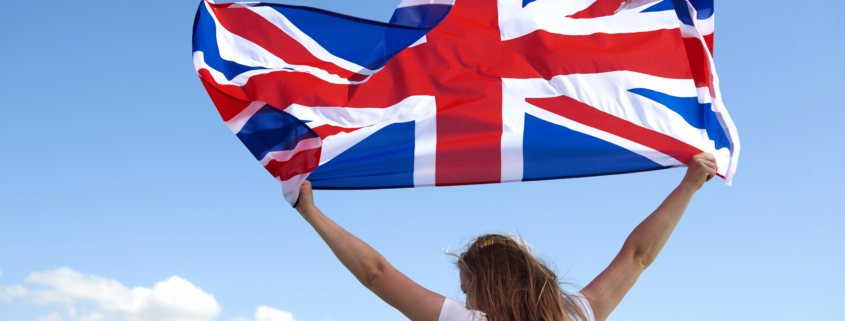 rear view of young woman waving the british flag